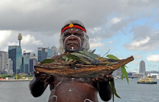 El anciano aborigen de Budgeoli, Max Eulo, realiza una ceremonia, 'Bienvenido al país' en Goat Island, o Me-Mel en el dialecto local. Fotografía tomada en el puerto de Sydney.
