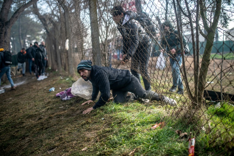 Un migrante se introduce en la zona intermediaria entre las fronteras griega y turca, en Pazarkule. (AFP)