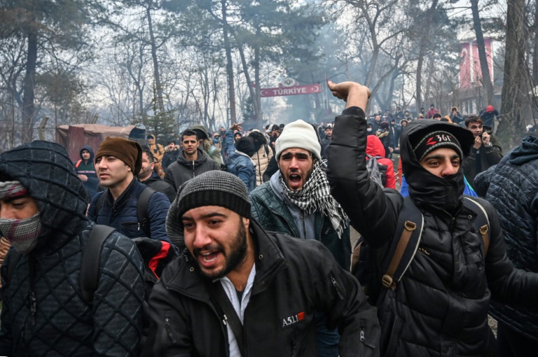 Un grupo de migrantes se enfrenta a la policía griega en la frontera entre Grecia y Turquía en Pazarkule. (AFP)